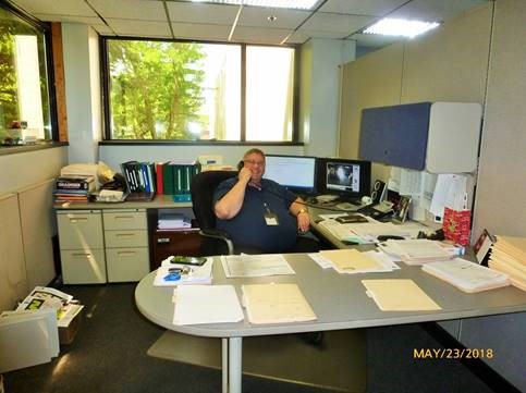 A picture of Paul Avery sitting at his desk, talking on the phone in 2018.